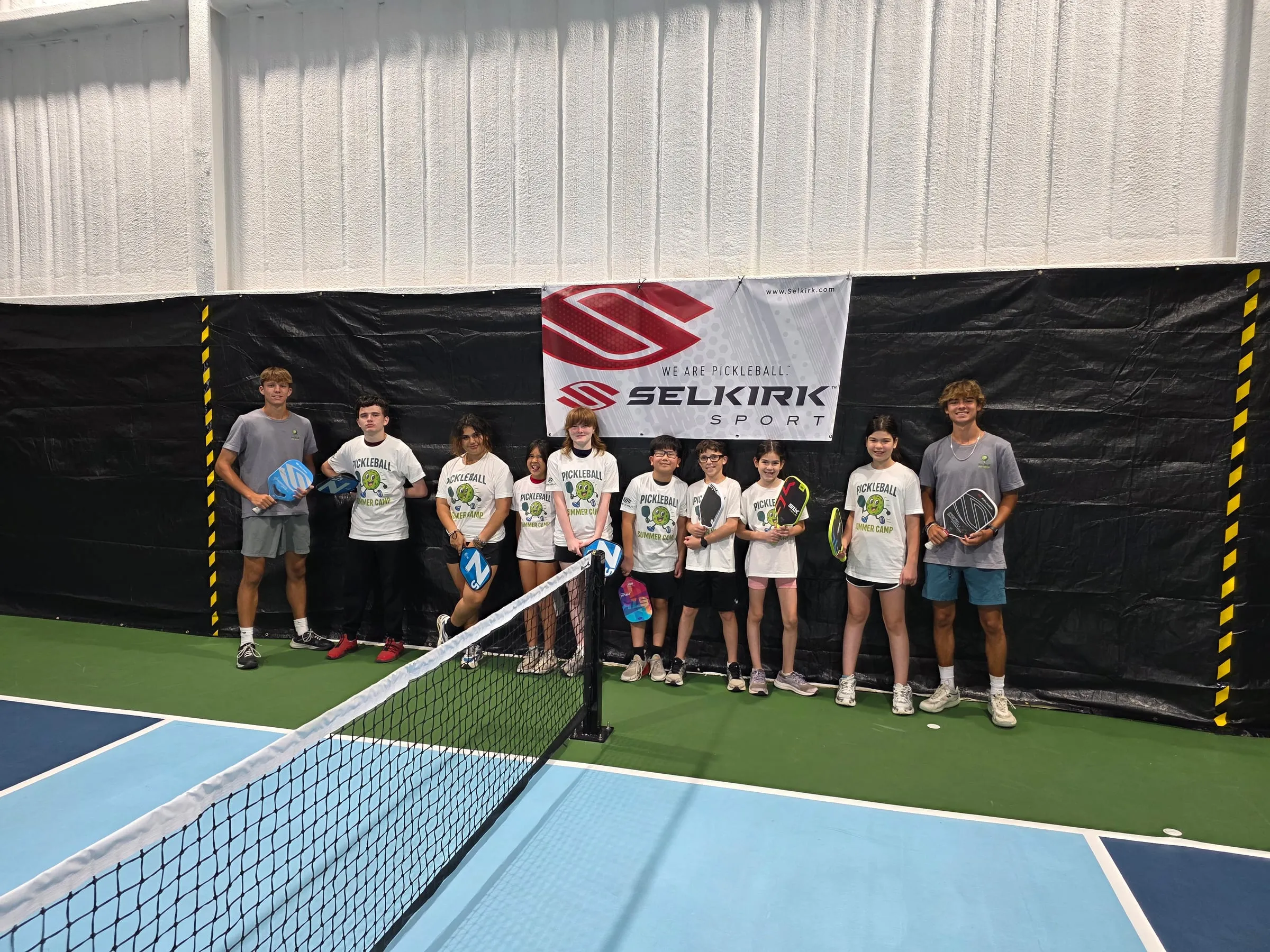 Summer campers lined up on court with their coaches
